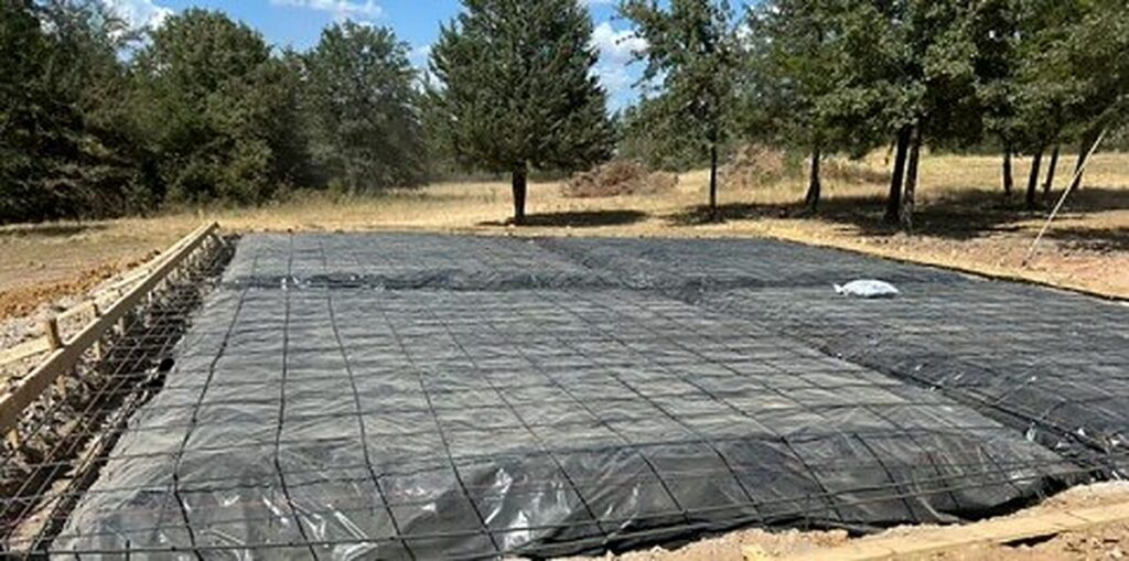 Shop pad with forms, vapor barrier and rebar grid ready for concrete near Bonham, TX