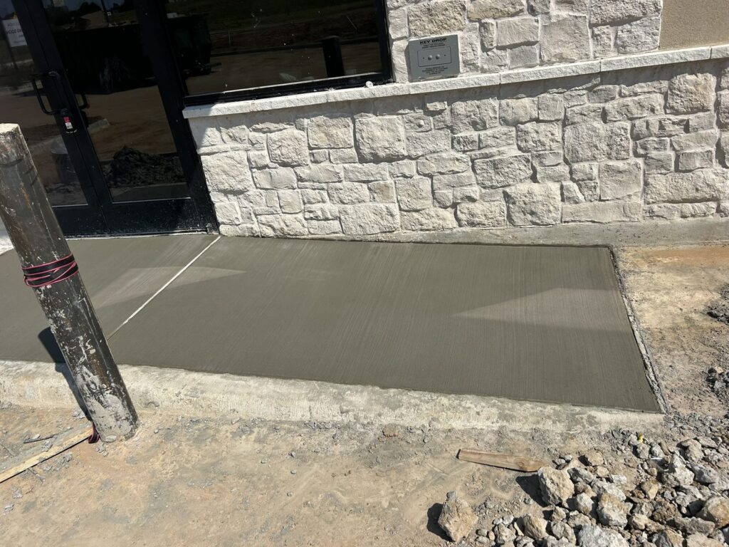 New concrete ADA ramp at a building entrance in Denison, TX